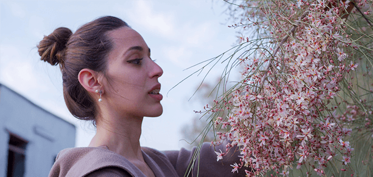 femme qui regarde des feures de Moringa Peregrina