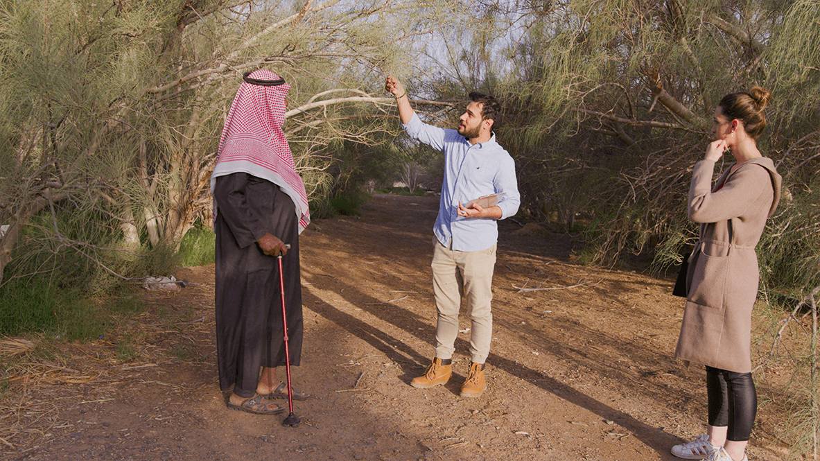 un homme montre une branche de Moringa